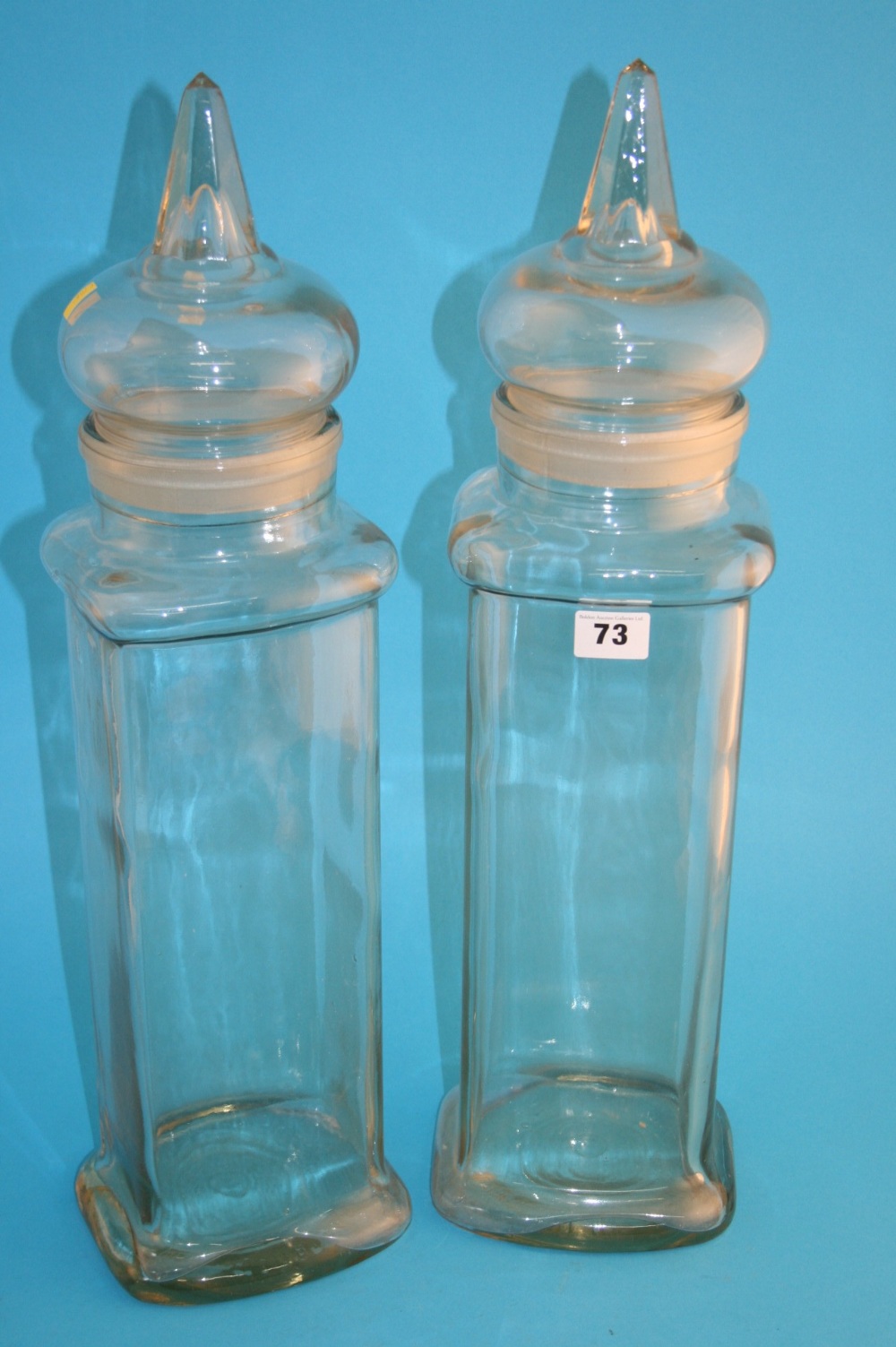 A tall pair of clear glass sweet jars and covers. 56.5 cm high