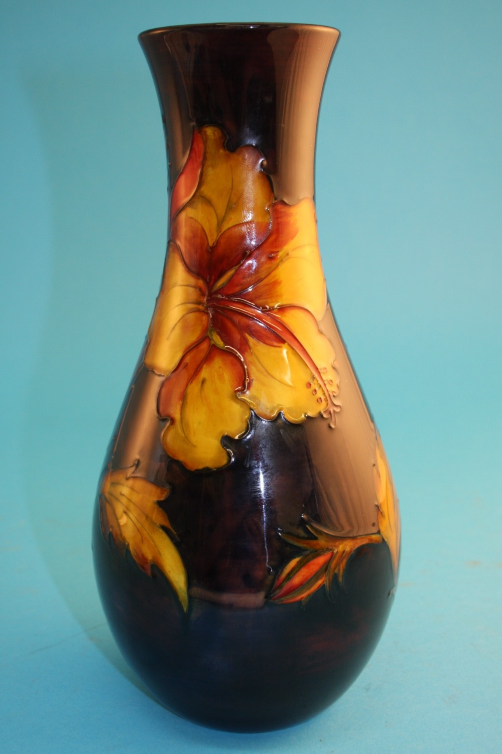 A Moorcroft "Hibiscus" pattern baluster shaped vase on an autumnal ground, impressed marks, signed