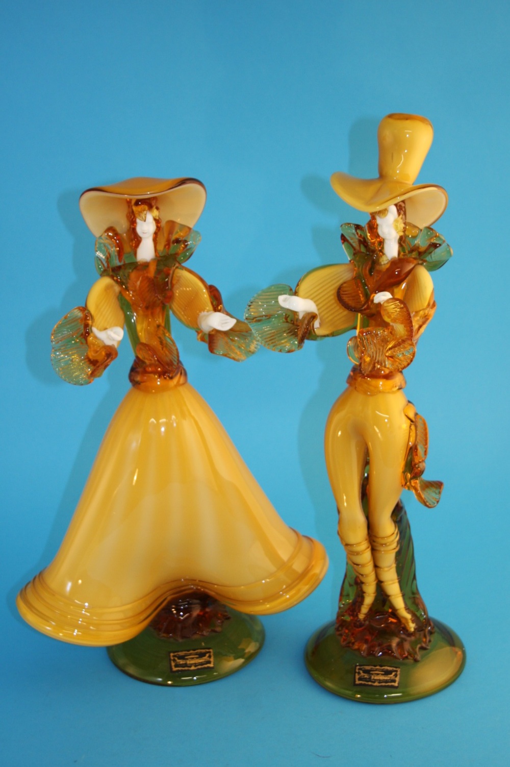 A pair of Venetian Glass Company amber coloured figures of a man and a woman. 17 cm high
