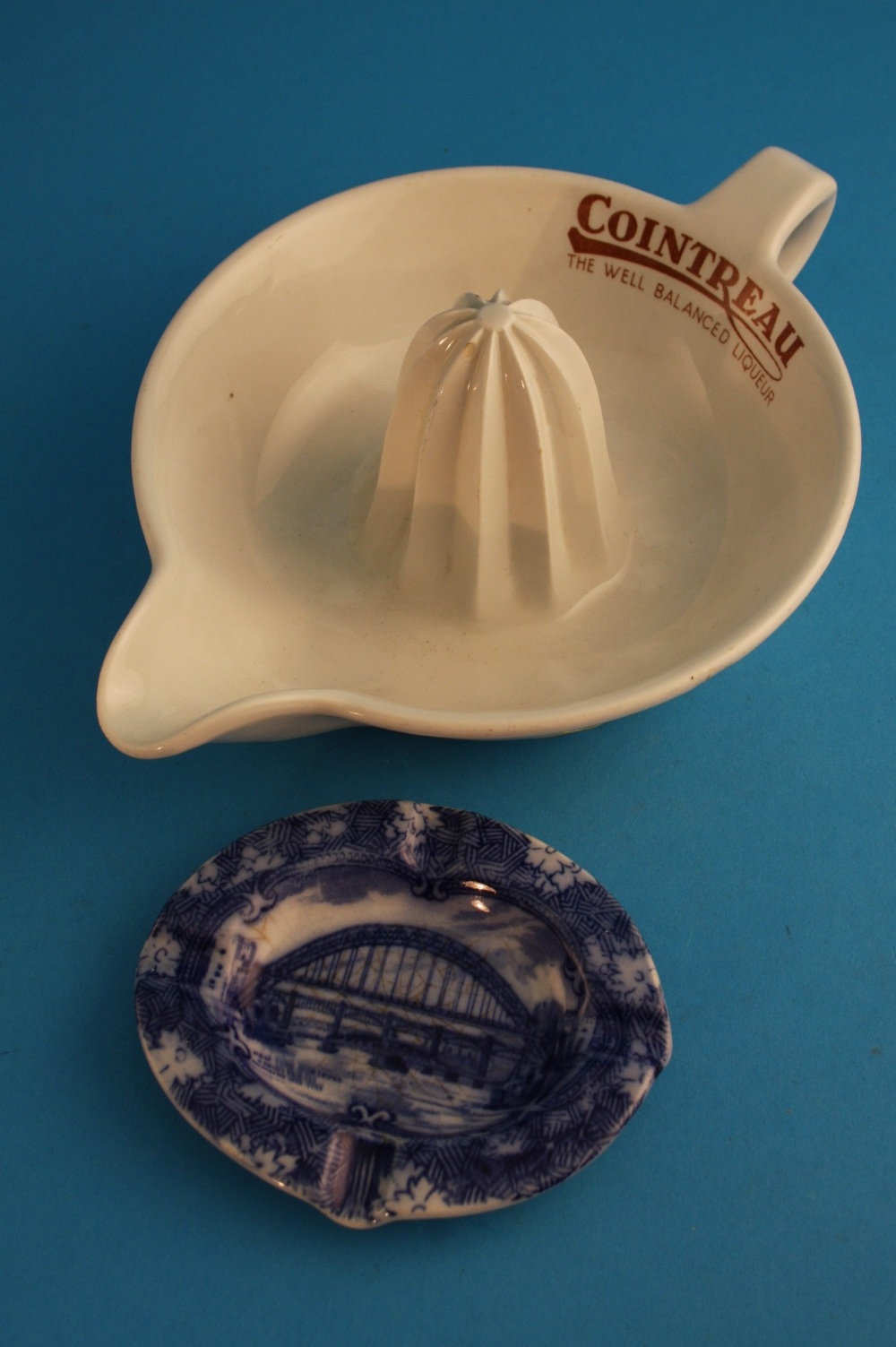 A Maling North East Coast 1929 Exhibition oval ashtray and a Maling "Cointreau" lemon squeezer, blue