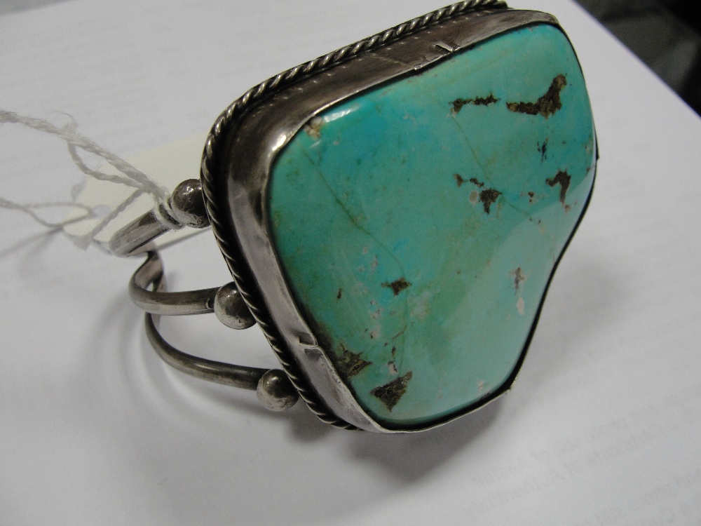 A large silver and turquoise bangle