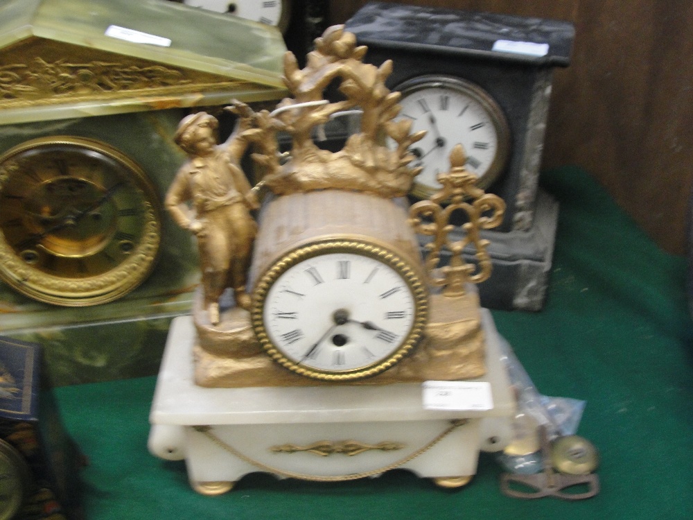 A gilded ormolu clock on a white marble base