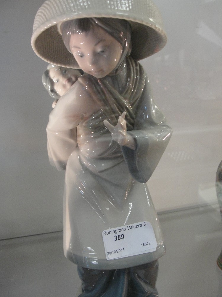 A Lladro Oriental figurine: Mother with child on back