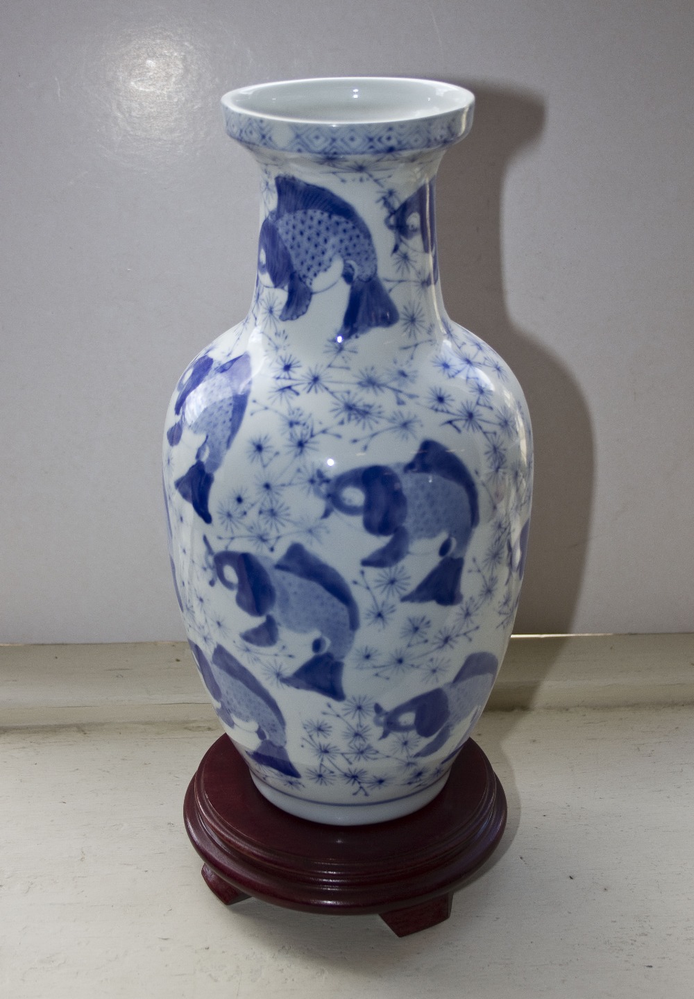 An oriental blue and white vase on hardwood stand