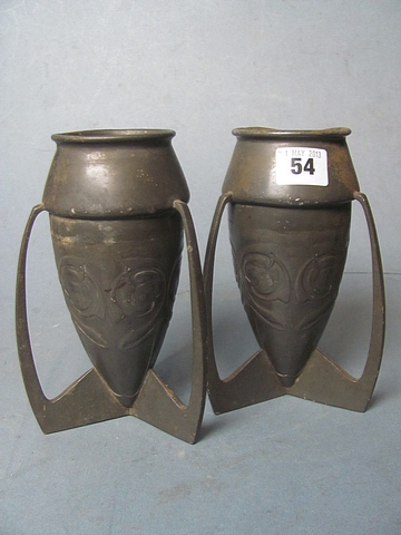 A pair of Liberty Archibald Knox pewter torpedo vases with raised decoration on raised supports,