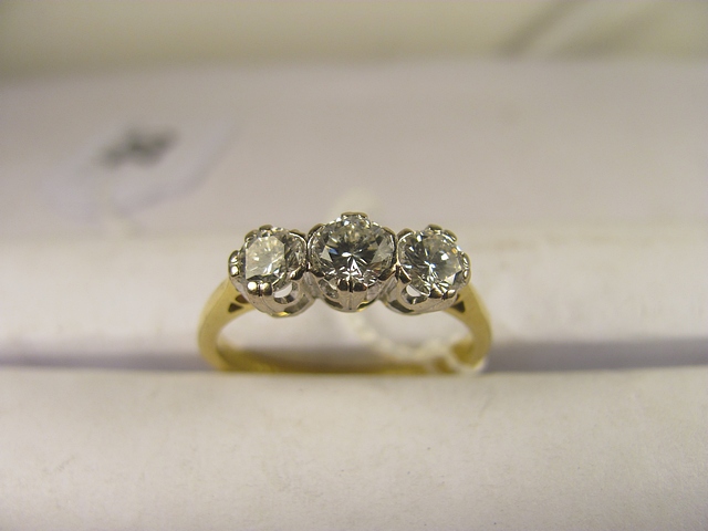 A 20th century 18ct gold three stone diamond ring set with three brilliant cut diamonds.