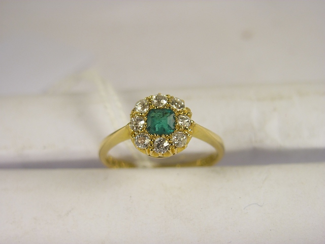 A 19th century 18ct yellow gold emerald and diamond cluster ring set with a square emerald and