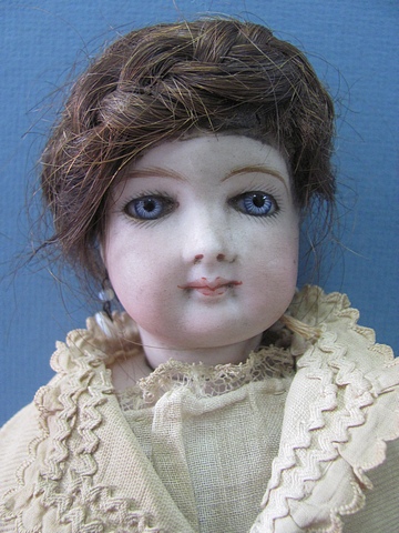 Circa 1880 a French Fashion doll (Poupee). Bisque swivel head on bisque shoulder plate, pale blue