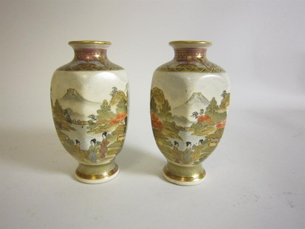 A pair of Satsuma Vases of octagonal form decorated figures within a landscape, 5in high