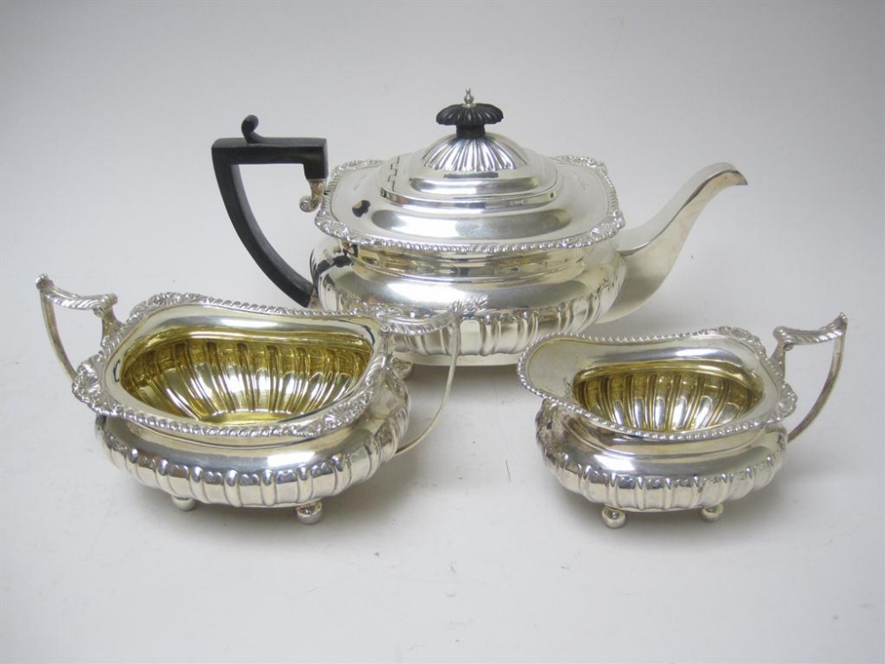 A George V three piece boat shape Tea Service, semi-fluted with gadroon rims on ball feet, Sheffield