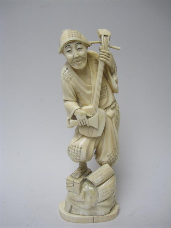 A Japanese ivory Figure of standing man playing stringed instrument, 10in, repaired