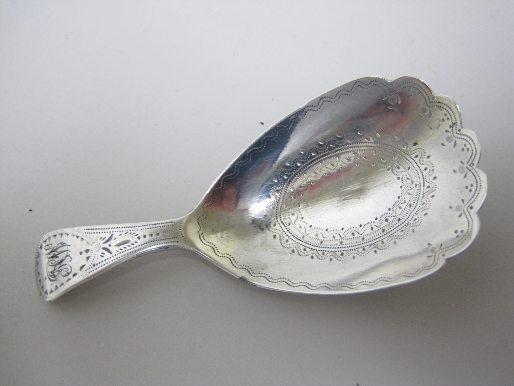 A George III Caddy Spoon with bright-cut oval bowl having vacant cartouche, stem engraved