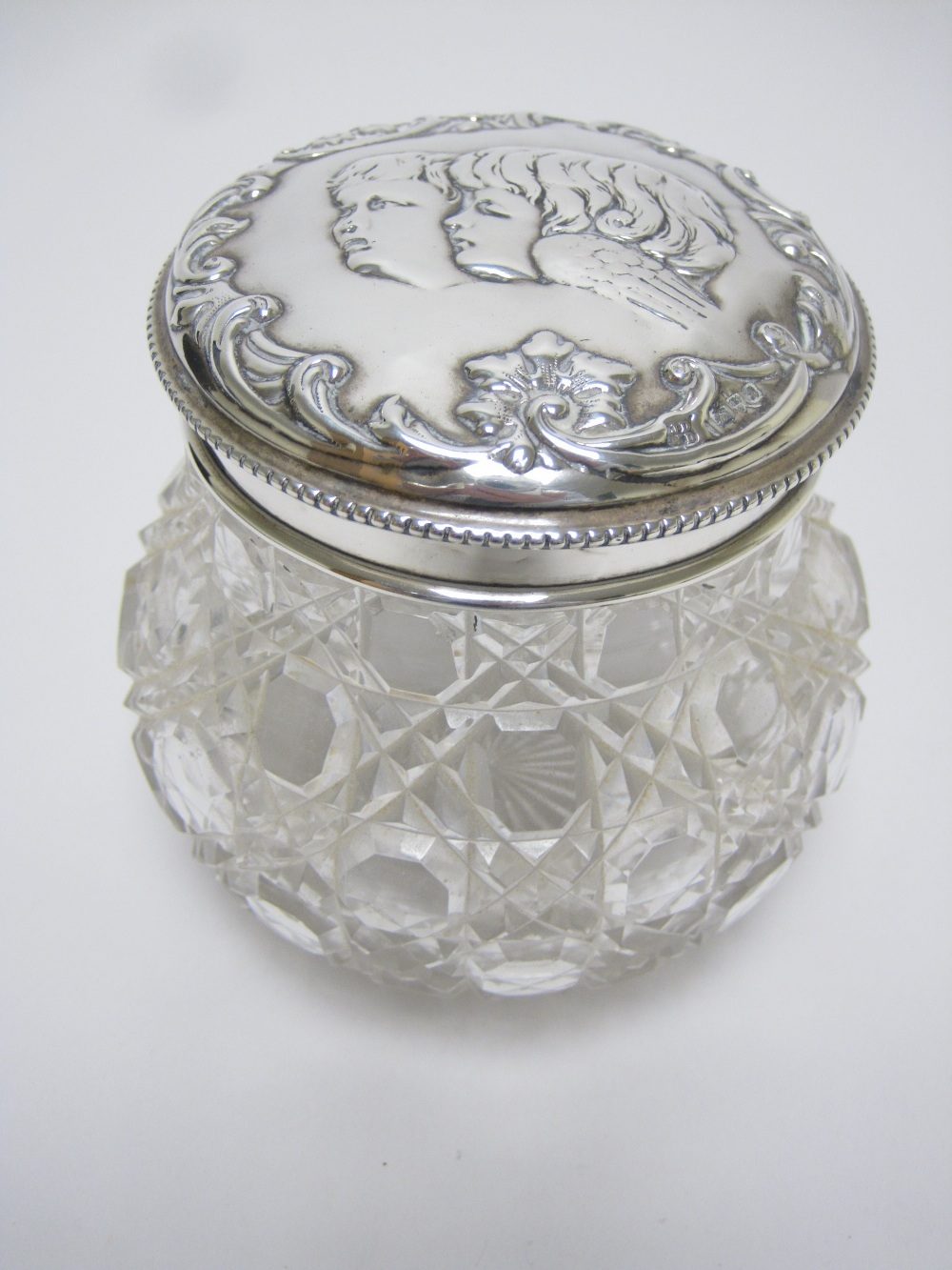 An Edward VII silver lidded cut glass Jar embossed cherub masks, Chester 1902, A/F