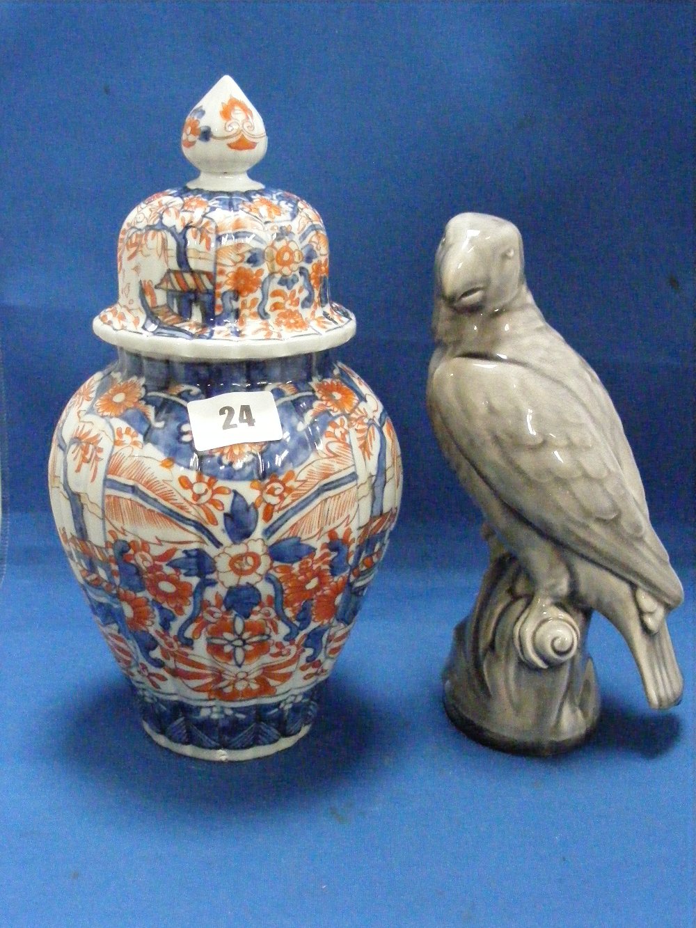 A Minton's figure of a parrot in grey and cream, together with an Imari pot and cover of baluster