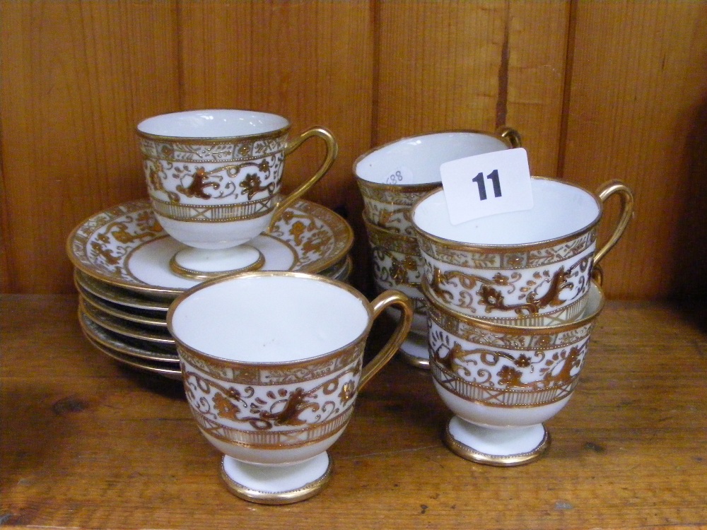 A set of six Noritake cups and saucers with gilt work decoration on a white ground.