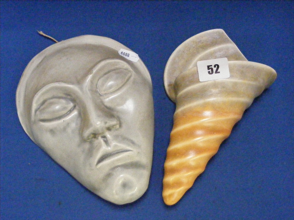 An Art Deco Beswick wall pocket in the form of a conch shell, together with a ceramic wall mask.