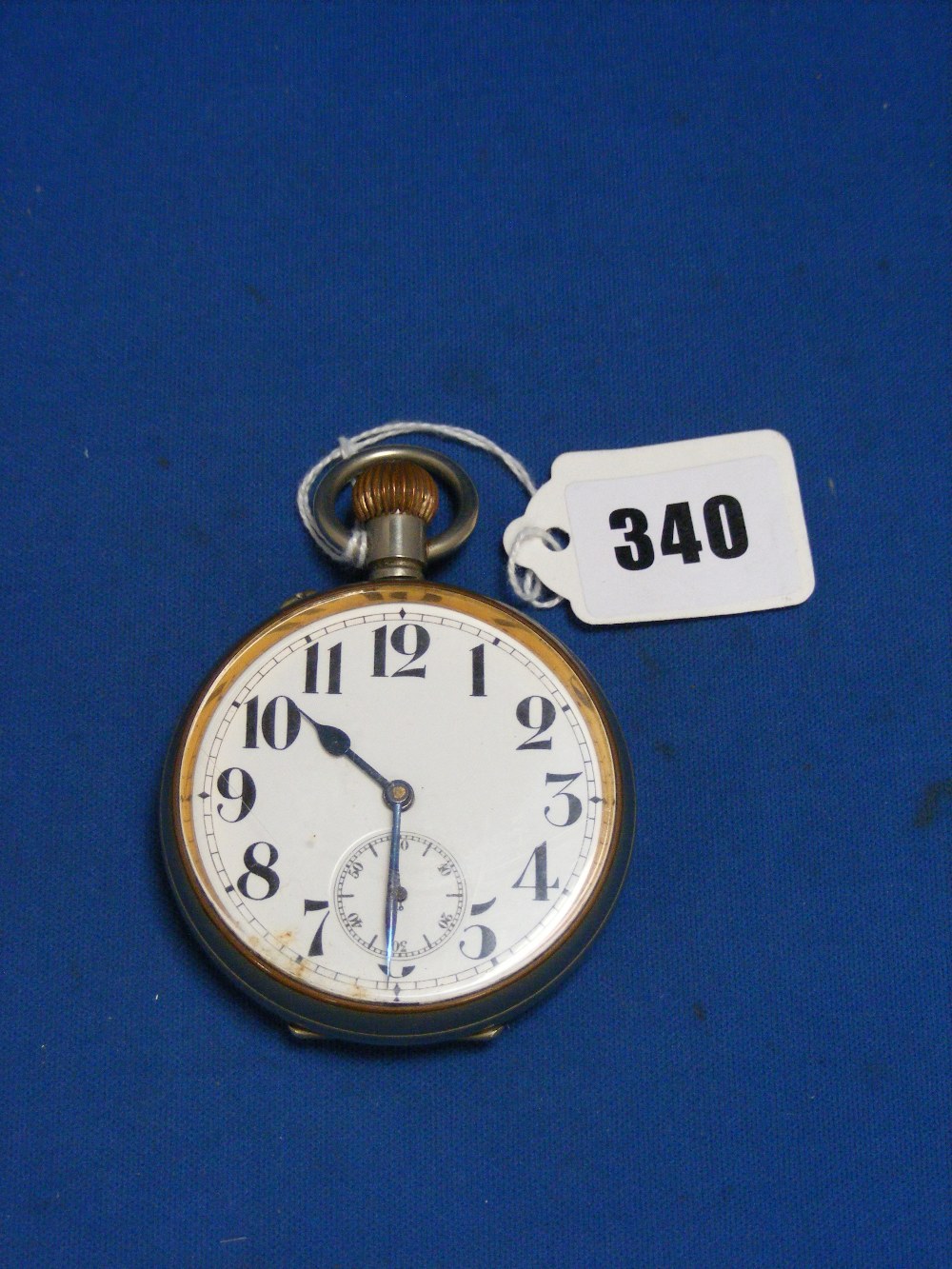 A steel cased pocket watch with Arabic numerals on a white face dial.