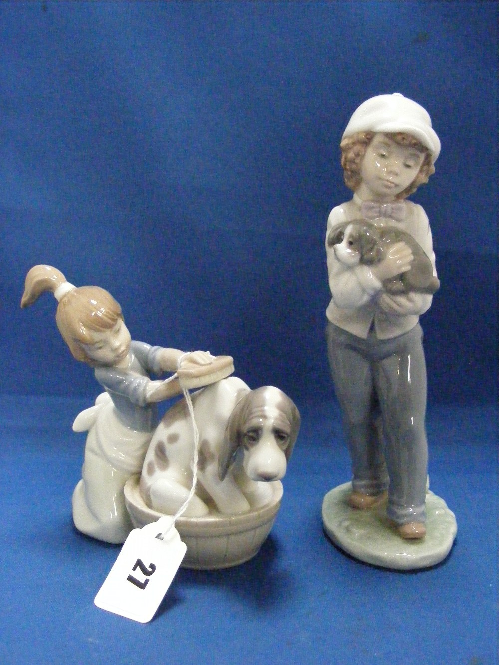 A Lladro figure entitled 'Bashful Bather 5455', together with a Nao figure of a child holding a