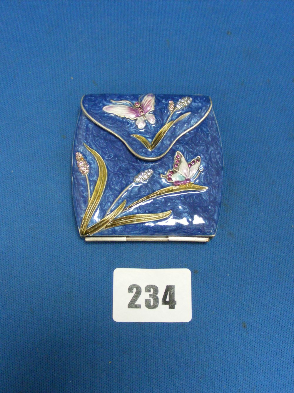 A very fine white metal and blue enamel compact/mirror in the style of a purse, decorated with