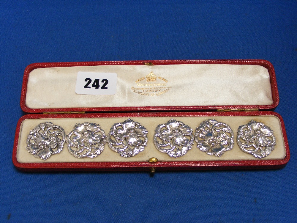 A cased set of six large English silver Art Nouveau buttons with pierced floral decoration and