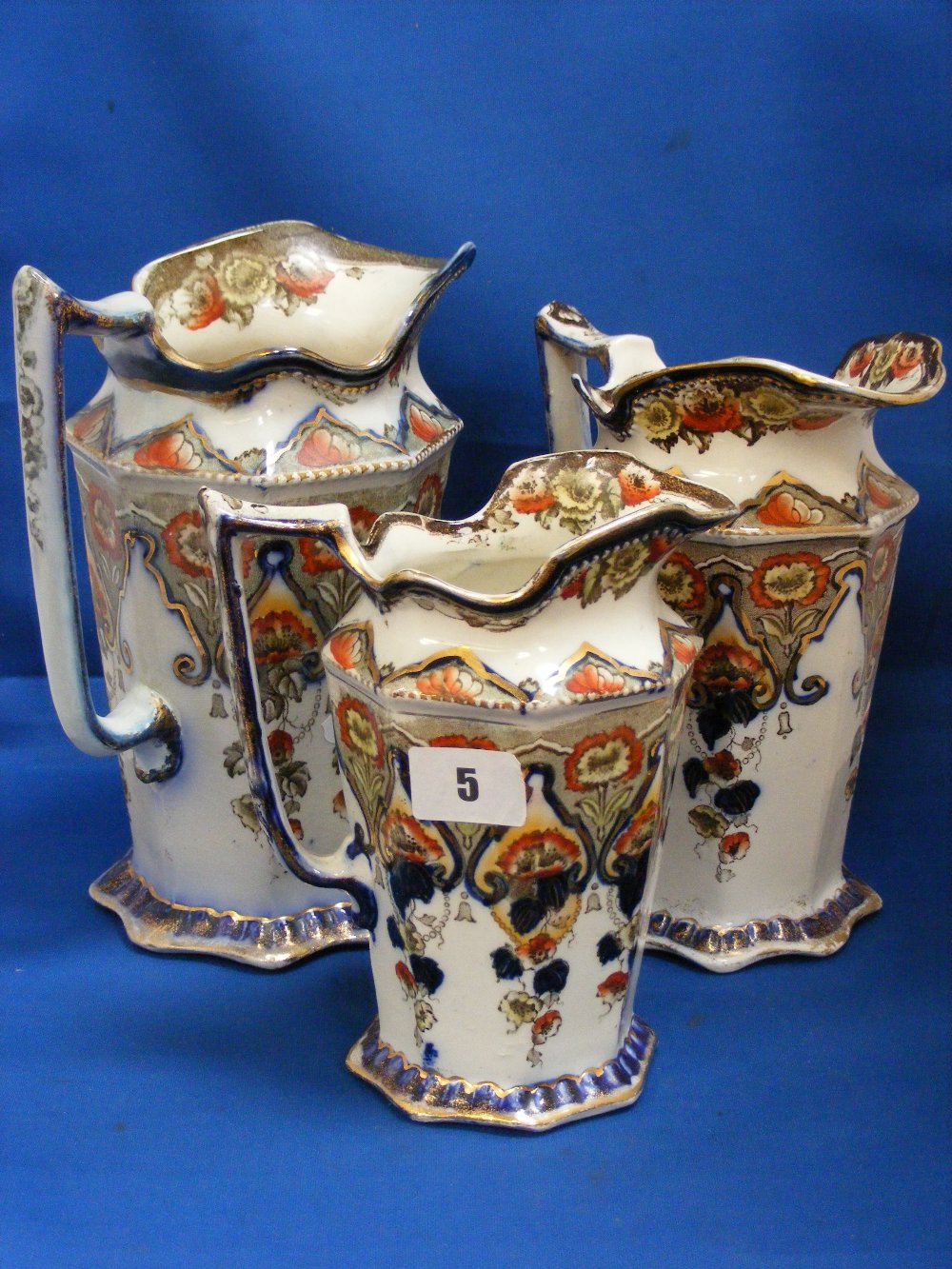 A set of three Victorian graduated octagonal jugs with transfer printed floral decoration on a cream