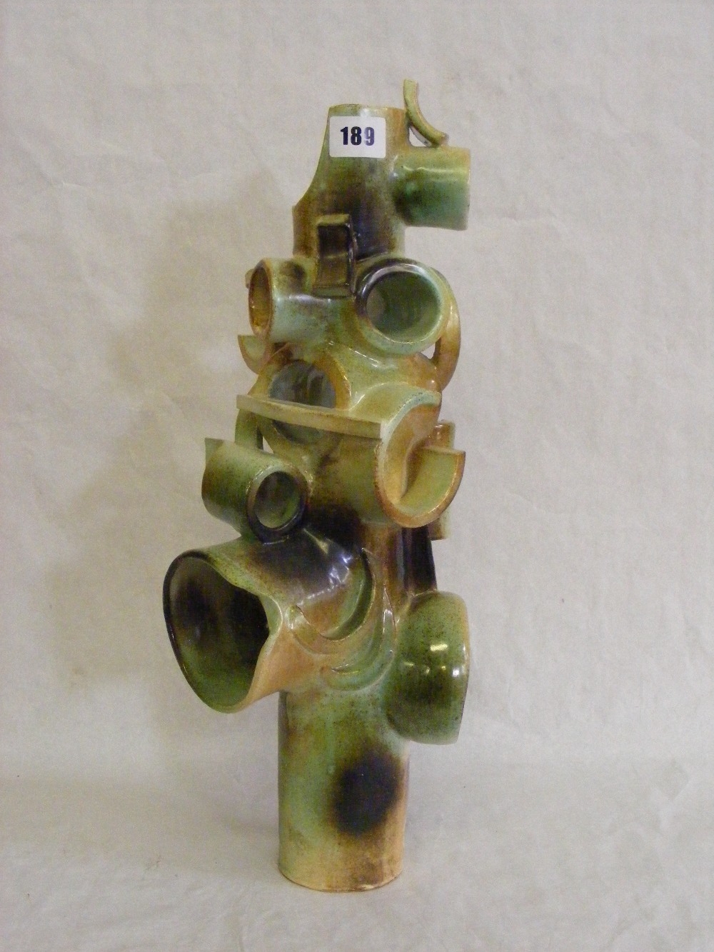 An Art Pottery ornament in green and brown and of modernist circular form.