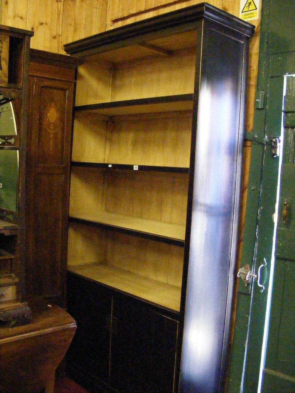 A large stained free standing bookcase, fitted two cupboard doors below.
