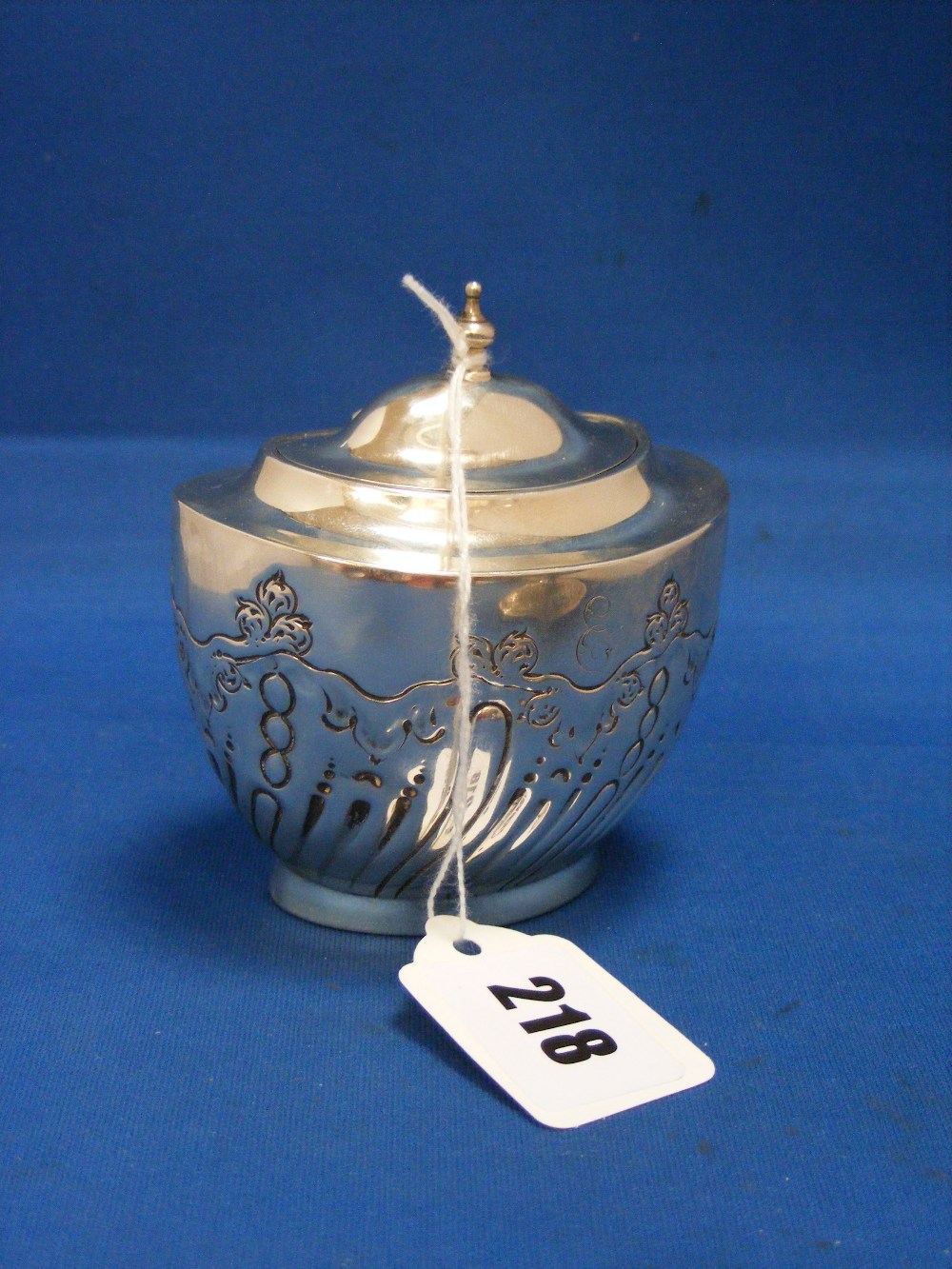 A decorative English silver hinged tea caddy with wavy sloping fluted decoration with globular and