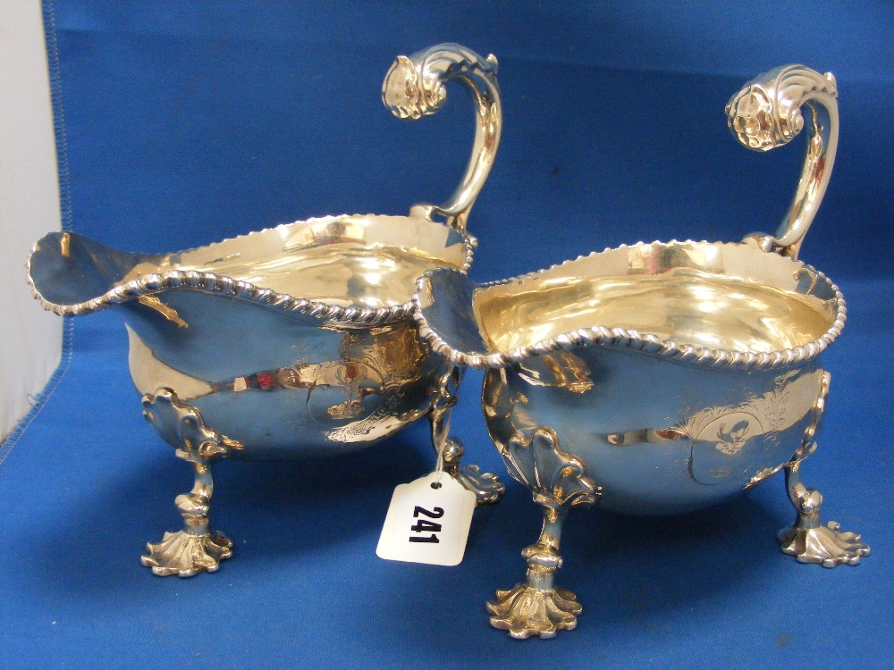 A very fine pair of Georgian sauce boats, London 1760, with upright scrolled handles on leaf