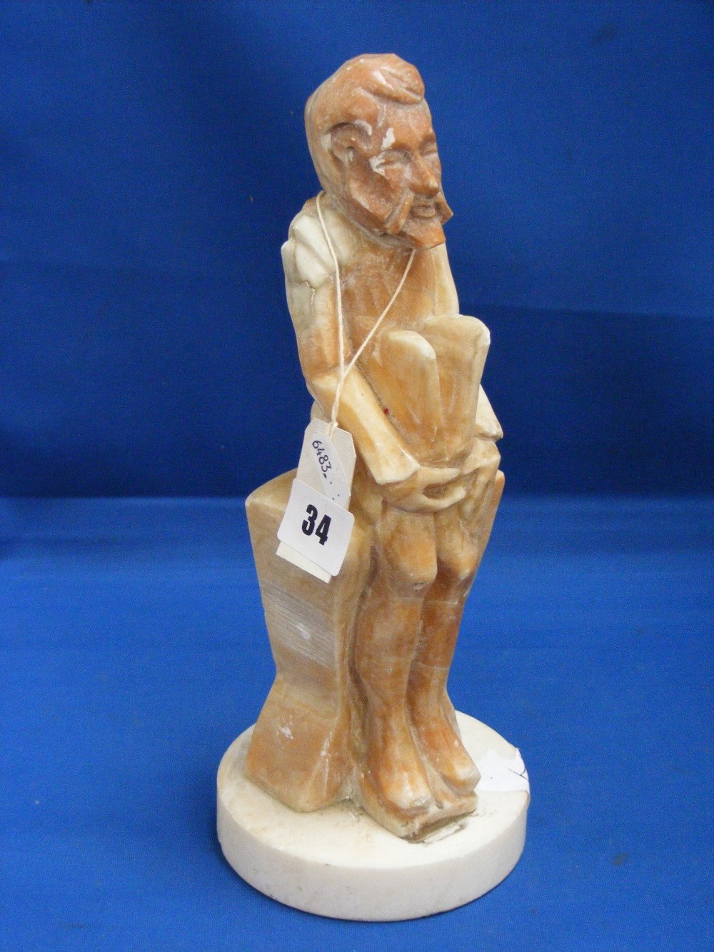 A carved soapstone figure of a seated man, height 29cms.