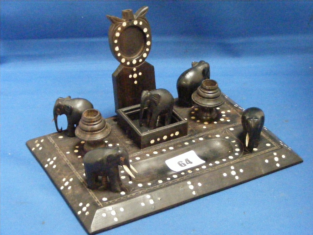 An ebonized desk stand inlaid with mother of pearl decoration and having five carved figures of