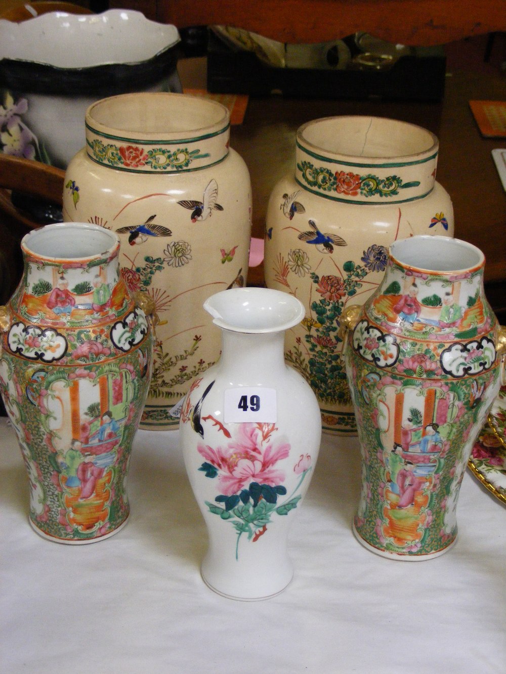 Two Oriental vases with hand painted decoration of birds, butterflies and flowers, on an ivory