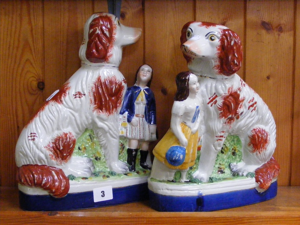 Two Staffordshire figures, both depicting an oversized spaniel and child, painted in naturalistic