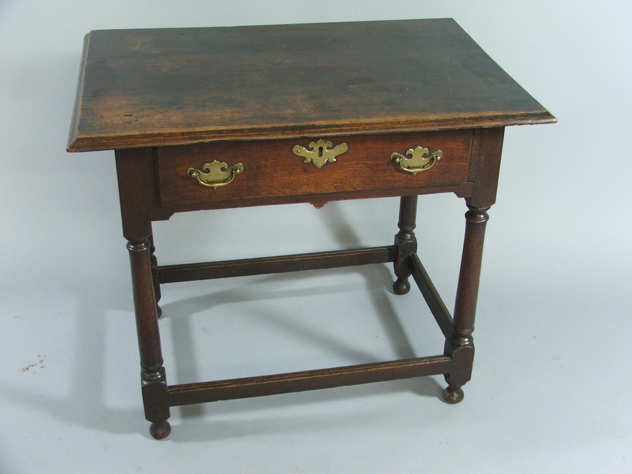 An Early Oak Side Table with Three Plank Top and Single Drawer with Brass Drop Handles and