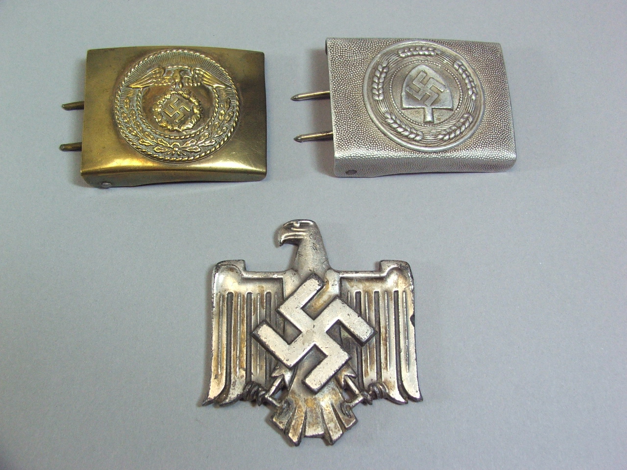 A Collection of Two Nazi Belt Buckles and Metal Eagle Staff Mount.