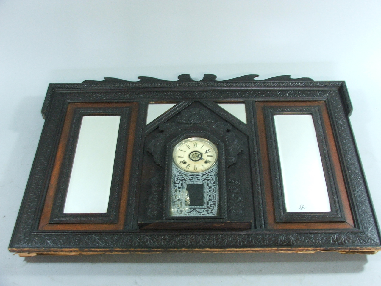 A Victorian Ebonised Overmantle Mirror with Inset Central Clock having Striking 8 Day Movement,