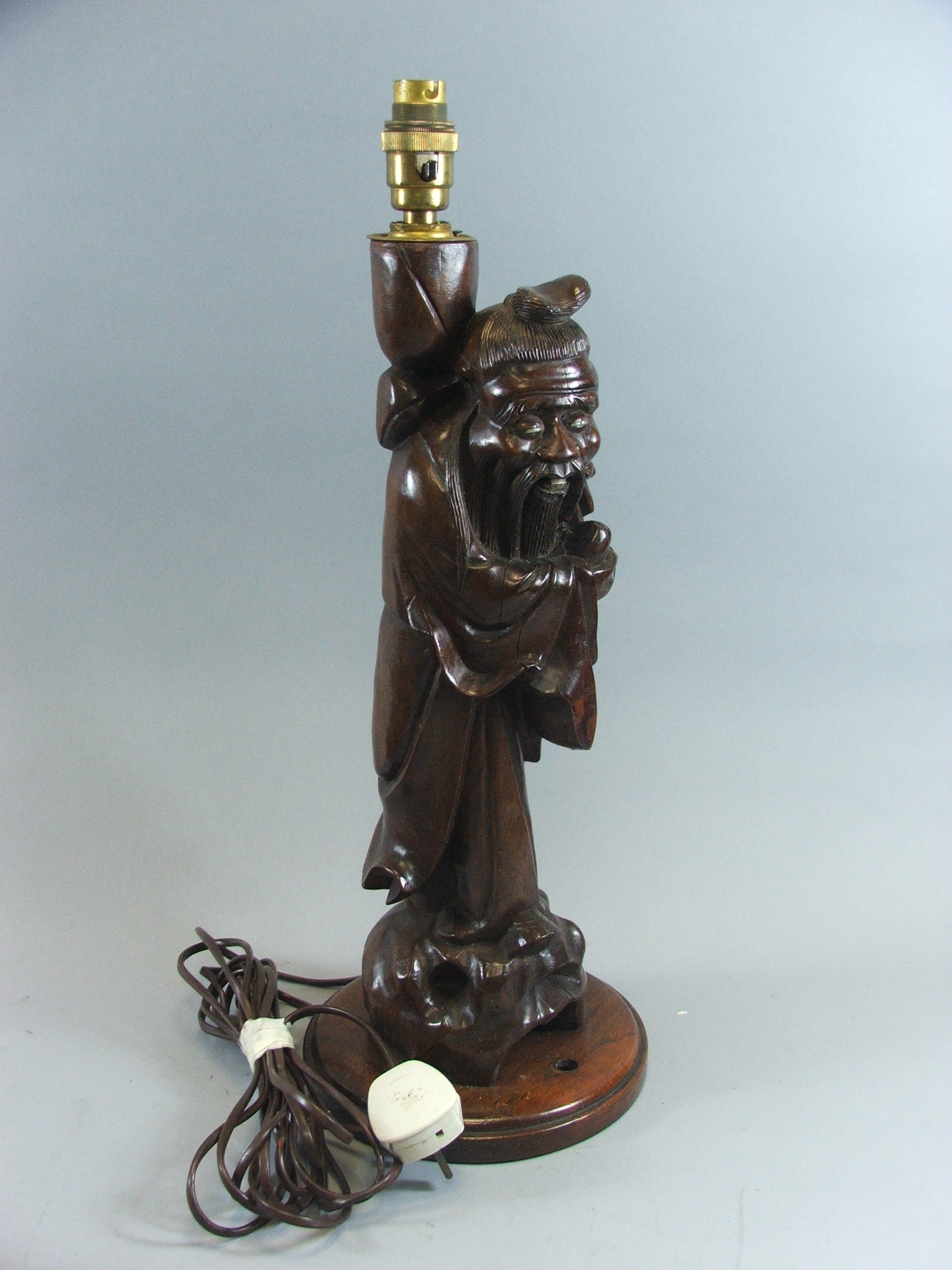 An Early 20th Century Chinese Carved Hardwood Table Lamp in the form of Shou Lao, Deity of