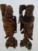 Two Oriental Carved Figures depicting two characters. 30 cms h The characters having glass eyes