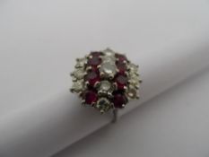 Lady`s 18ct White Gold Ruby and Diamond Cluster Ring, eight 3.3mm rubies, one 4.4mm 33pts diamond