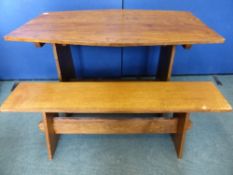 An Arts and Crafts style oak dining table supported on each by a panel united by a pegged stretcher,