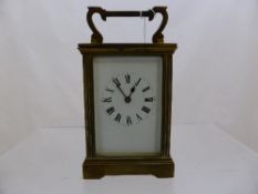 French Brass Carriage Clock with white enamel face and Roman numerals.