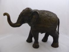 A vintage bronze effect Indian elephant adorned with elaborate saddle and head covering, approx.