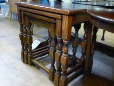 A nest of three mahogany tables on partially turned legs.