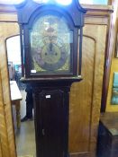 An oak cased antique grandfather clock, the clock being eight day and having a brass face, the