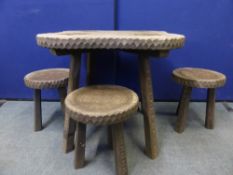 An Edwardian scalloped edge table on four slightly splayed legs with carved decoration, the top