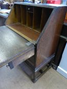 A small Edwardian oak bureau having pigeon holes and a small drawer to the interior with two drawers