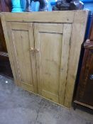 A vintage pine cupboard having two doors enclosing three shelves, approx. 95 x 108 x 32 cms.