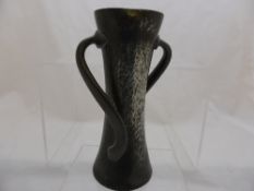 An English arts and crafts Tudric style vase having hammered finish with twisted handles, approx. 18