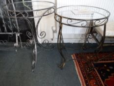 Two round wrought iron glass topped tables, approx. 62 cms diam. and 76 cms. high together with a