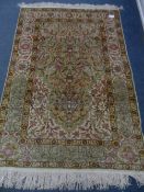 A Turkish Hereke silk rug the rug decorated with green, pink, yellow and blue floral motifs with